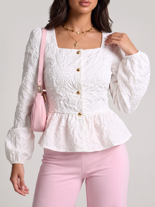 Woman wearing a white peplum blouse with a square neckline and front buttons